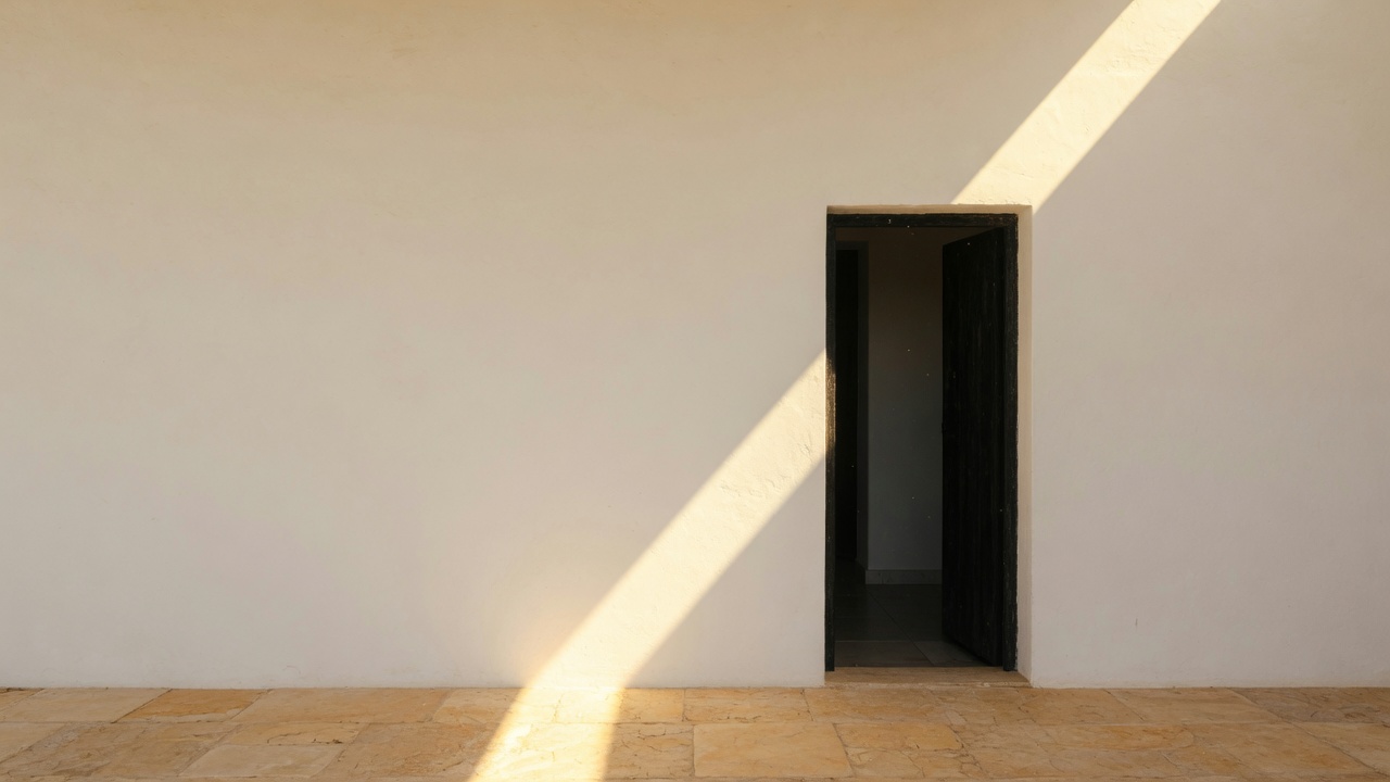 Parede clara, um vão e um rasgo de luz